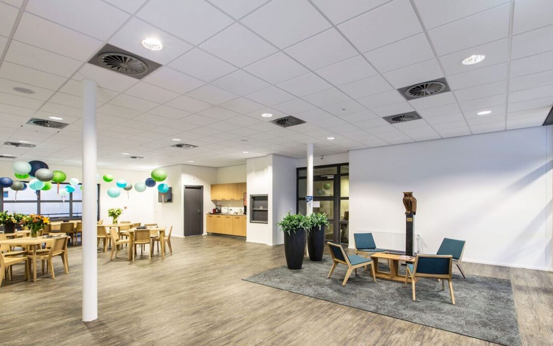 Espace d’accueil d’un local professionnel ouvert au public, avec coin attente et tables